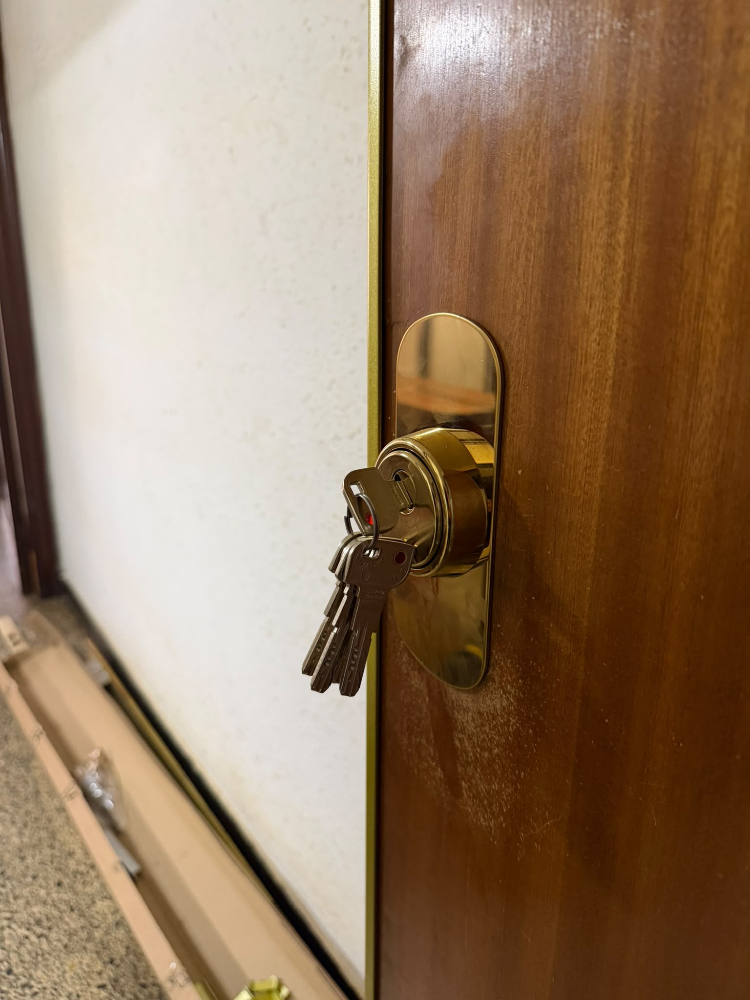 Bombín dorado con llaves en puerta de madera