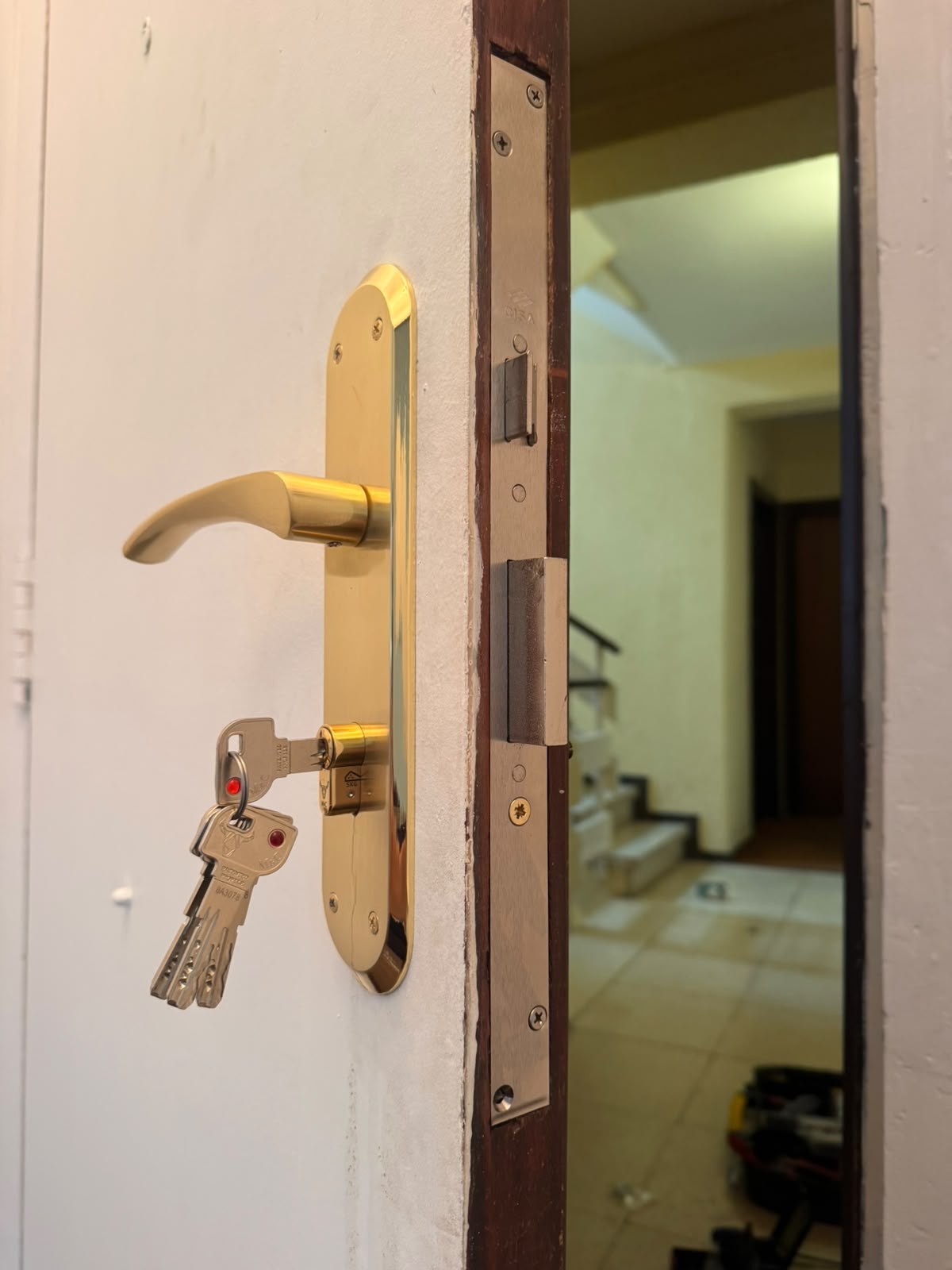 Cerradura con maneta dorada y llaves en puerta