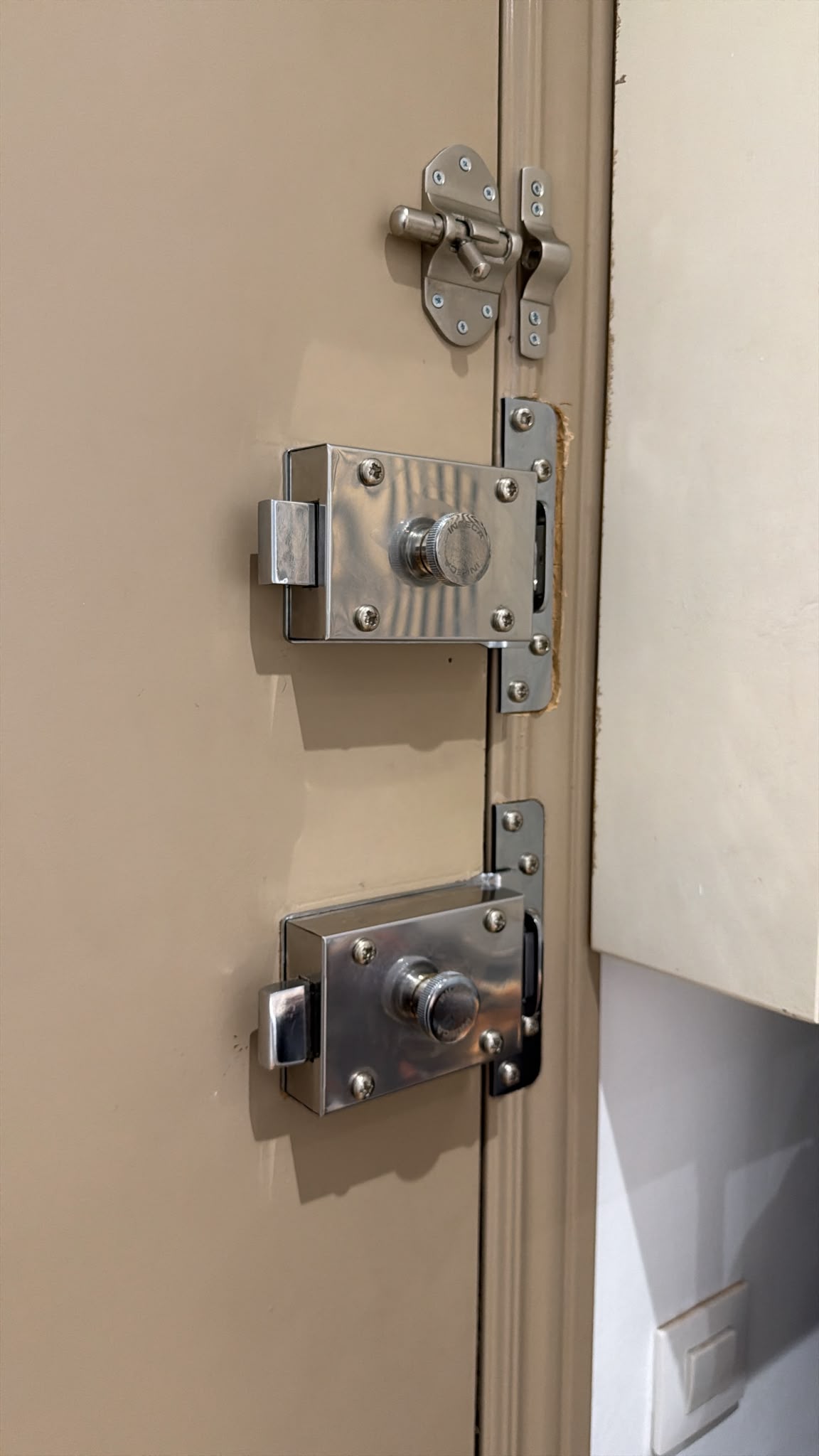 Dos cerrojos de seguridad y pestillo instalados en puerta