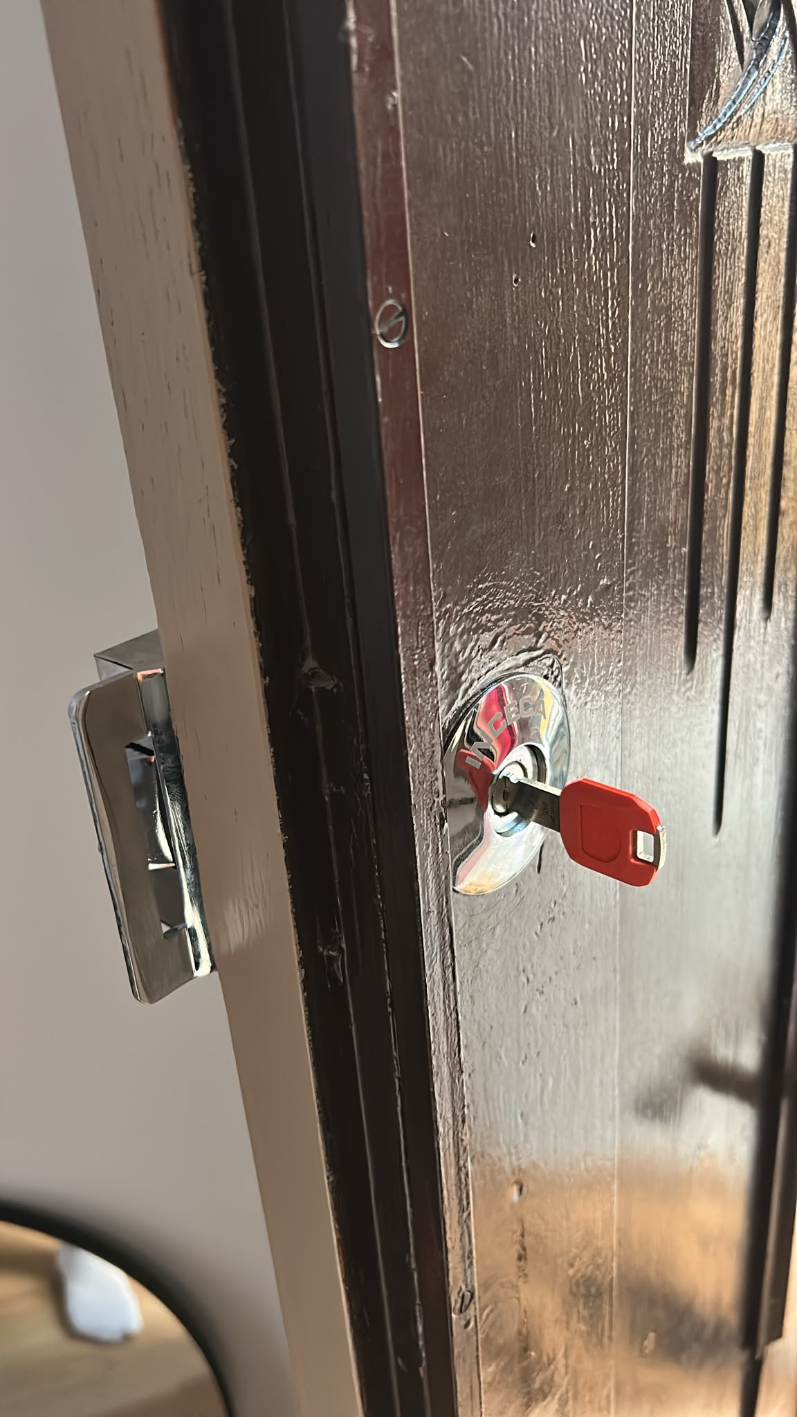Llave roja insertada en bombín de puerta oscura
