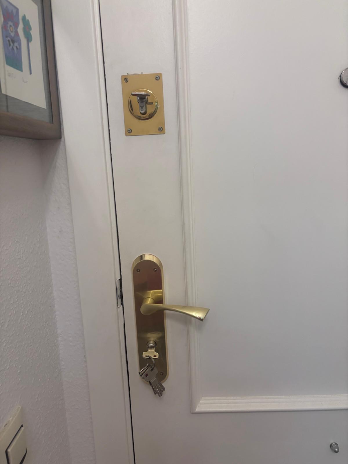 Llaves olvidadas en la cerradura de una puerta de vivienda, una de las situaciones que llevan a cambiar la cerradura