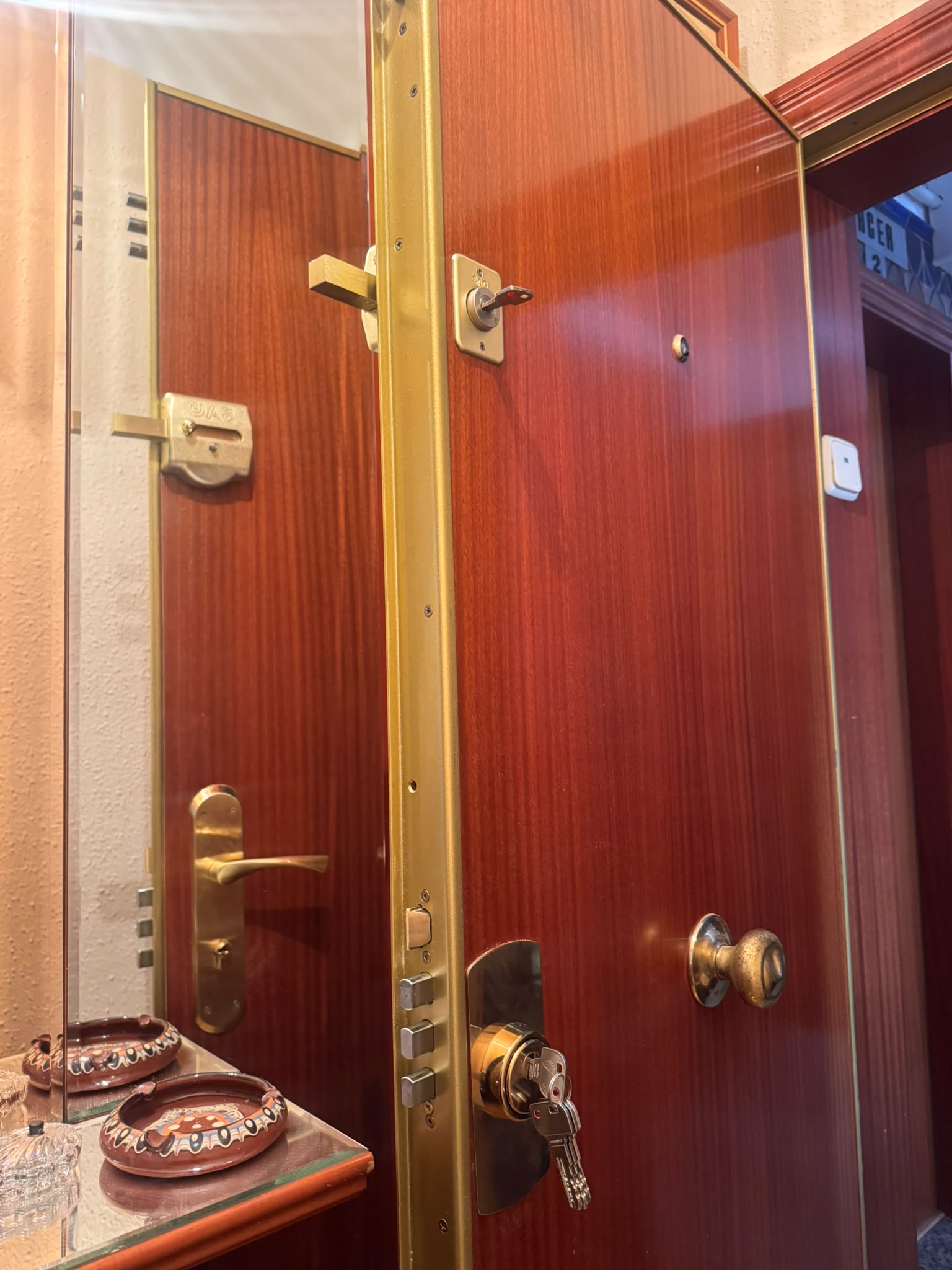 Puerta de seguridad abierta con el frontal de acero y el marco a la vista, el conjunto que decide si compensa repararla